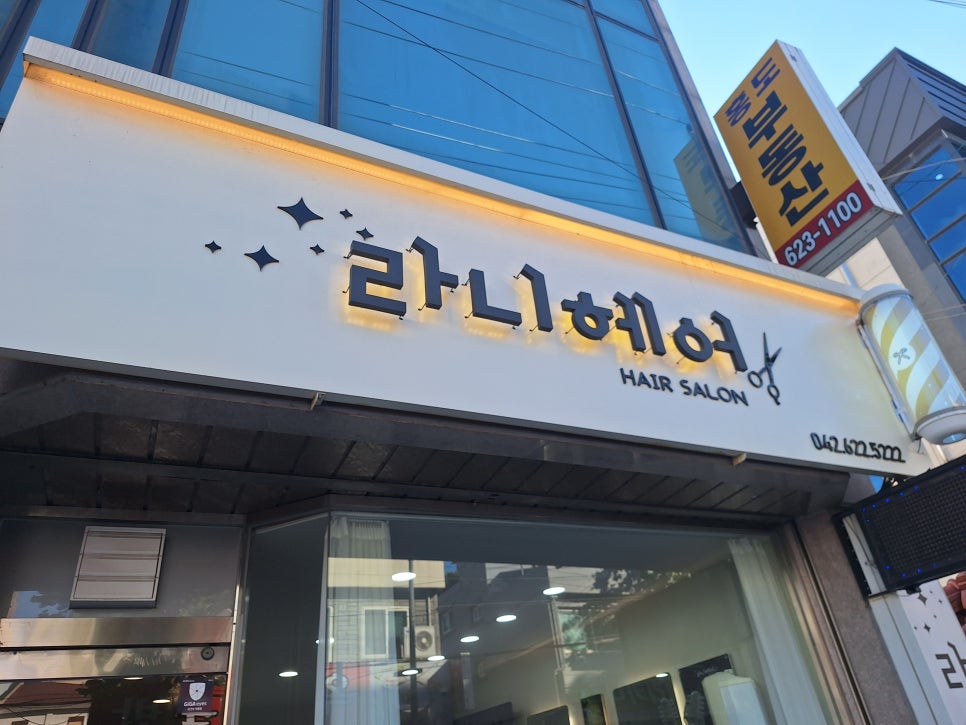 라니헤어 글자와 가위 그림이 있는 미용실 외부 간판